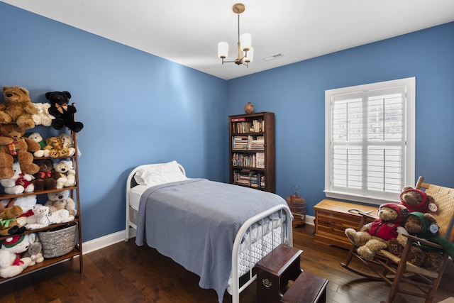 bedroom featuring a notable chandelier and dark hardwood / wood-style flooring