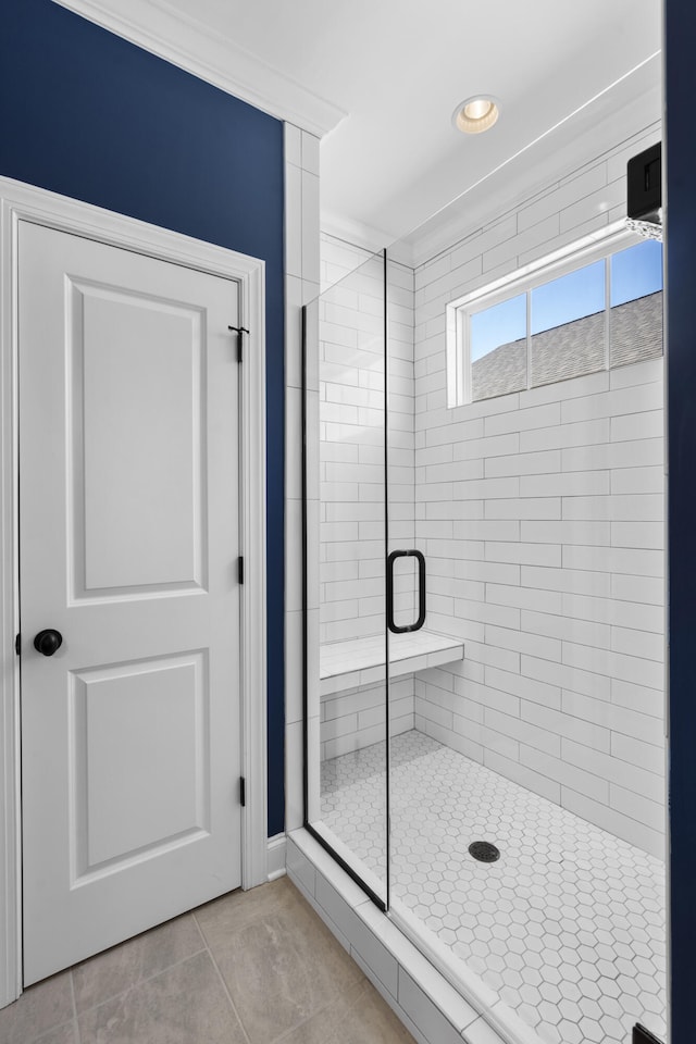 bathroom with tile patterned floors, ornamental molding, and walk in shower