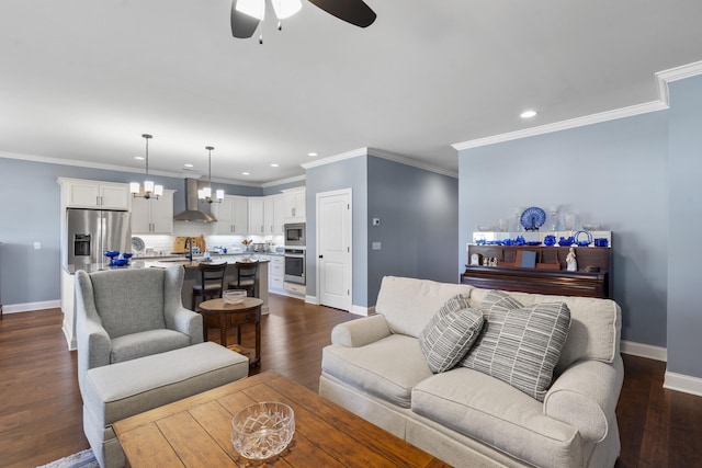 living room featuring ceiling fan with notable chandelier, crown molding, dark wood-type flooring, and sink