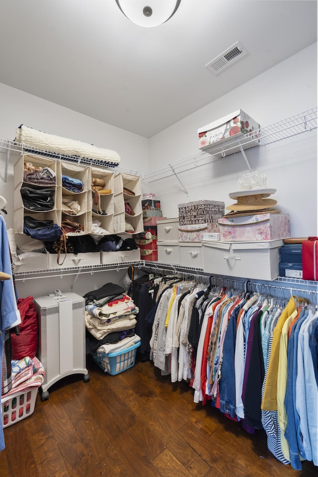 spacious closet with dark hardwood / wood-style flooring