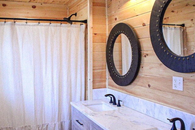 bathroom featuring wood walls and vanity