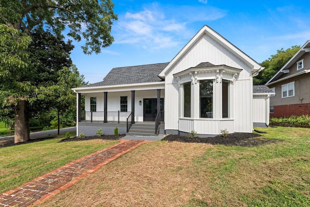 modern farmhouse with a front lawn and a porch