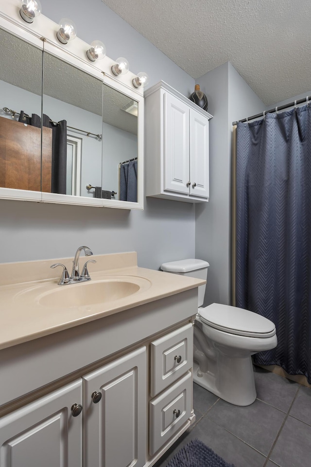 bathroom featuring tile patterned flooring, toilet, a textured ceiling, and vanity