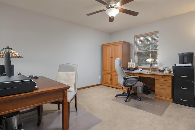 office space with baseboards, light carpet, and a ceiling fan