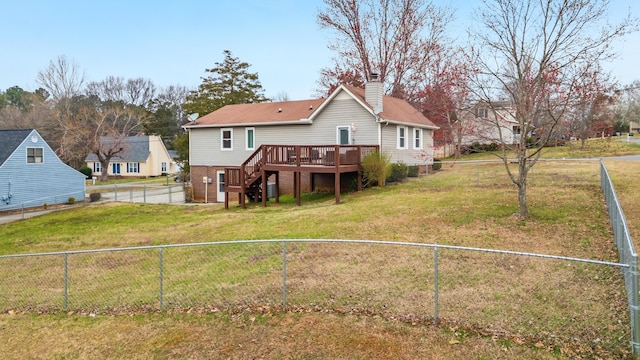 back of property featuring a wooden deck, a fenced backyard, a chimney, stairs, and a lawn