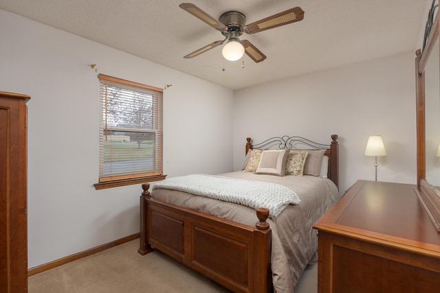 bedroom with light carpet, a ceiling fan, and baseboards