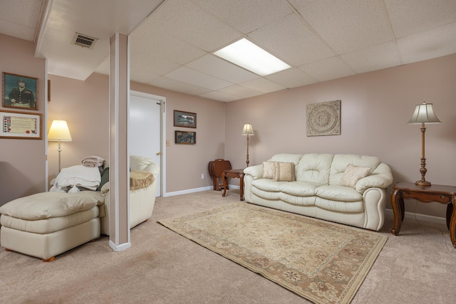 living area featuring a drop ceiling, visible vents, baseboards, and carpet floors