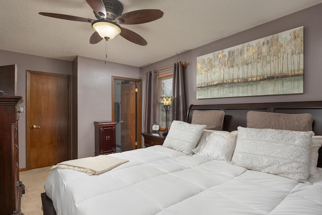 carpeted bedroom with ceiling fan and a textured ceiling