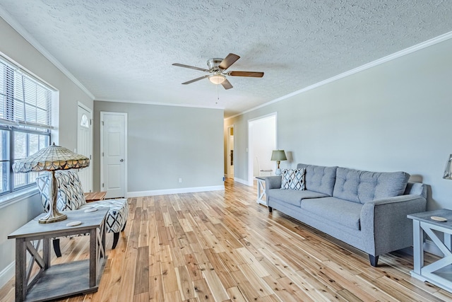 living area featuring light wood-style flooring, baseboards, ceiling fan, and ornamental molding