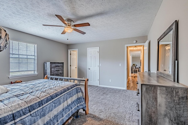 carpeted bedroom featuring ceiling fan, a textured ceiling, and baseboards