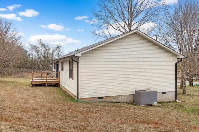 view of side of home featuring a deck, central AC, a yard, and crawl space