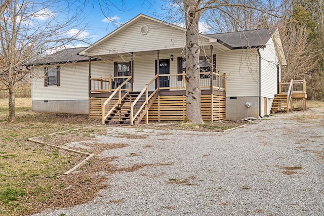 view of front of house with crawl space, covered porch, and stairway