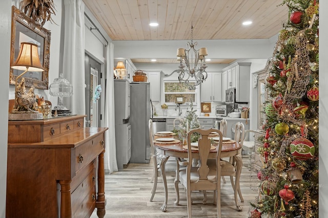 dining room with a chandelier, light wood-type flooring, and wooden ceiling