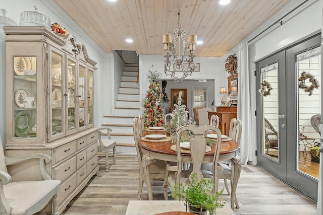 dining space with light hardwood / wood-style floors, wooden ceiling, and french doors