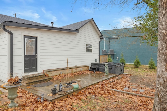 back of house with a hot tub and central air condition unit