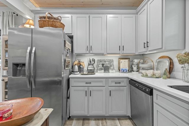 kitchen with gray cabinets, dark hardwood / wood-style flooring, and stainless steel appliances