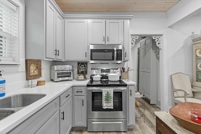 kitchen with wooden ceiling, stainless steel appliances, backsplash, light hardwood / wood-style floors, and gray cabinets