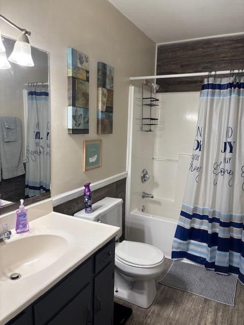 full bathroom featuring shower / bathtub combination with curtain, hardwood / wood-style floors, vanity, and toilet