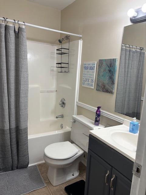 full bathroom featuring tile patterned floors, shower / tub combo with curtain, vanity, and toilet