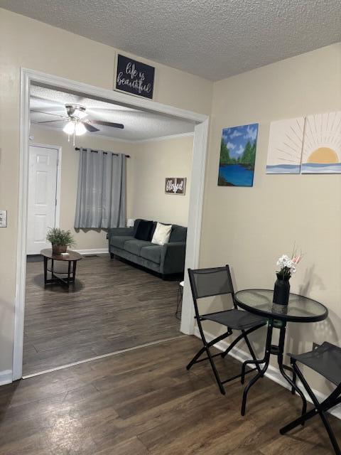 dining room featuring ceiling fan, dark hardwood / wood-style flooring, and a textured ceiling