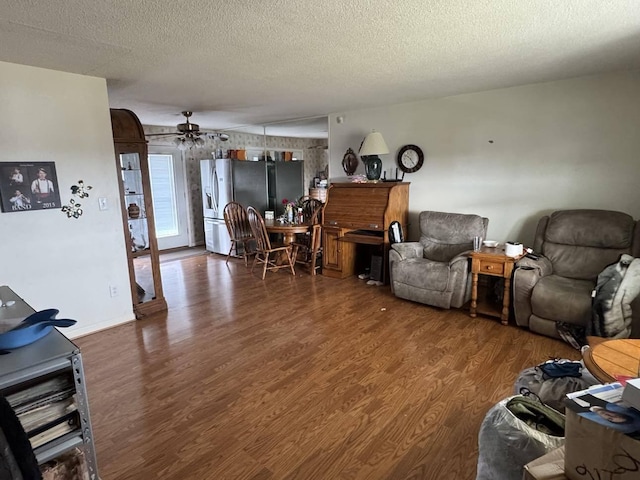 living room featuring dark wood-type flooring and a textured ceiling