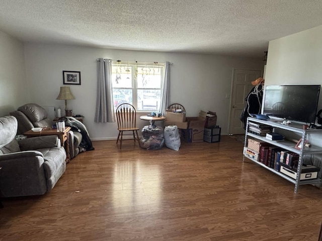 living room with a textured ceiling and dark hardwood / wood-style floors