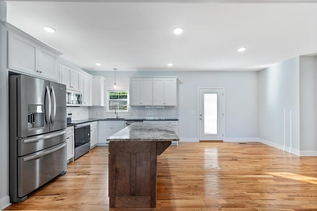 605 Westover Dr SW, Cleveland, TN 37311 - kitchen featuring appliances with stainless steel finishes, light wood-style flooring, a kitchen island, tasteful backsplash, and recessed lighting