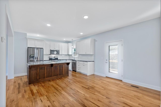 605 Westover Dr SW, Cleveland, TN 37311 - kitchen featuring stainless steel appliances, a center island, white cabinets, tasteful backsplash, and light wood-style floors