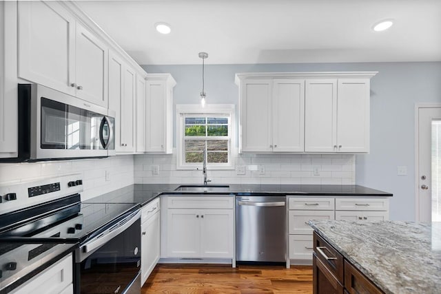 605 Westover Dr SW, Cleveland, TN 37311 - kitchen with stainless steel appliances, white cabinetry, wood finished floors, hanging light fixtures, and recessed lighting