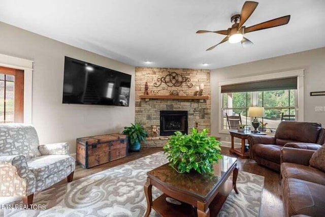 living room featuring a fireplace, hardwood / wood-style floors, and ceiling fan