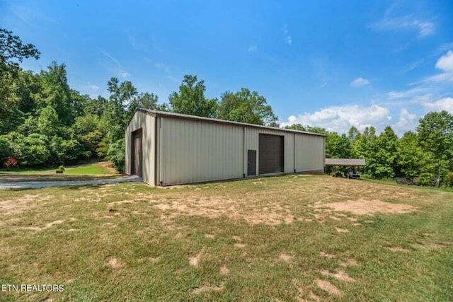 view of outdoor structure with a garage and a lawn