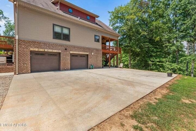 view of side of property with a garage and a wooden deck