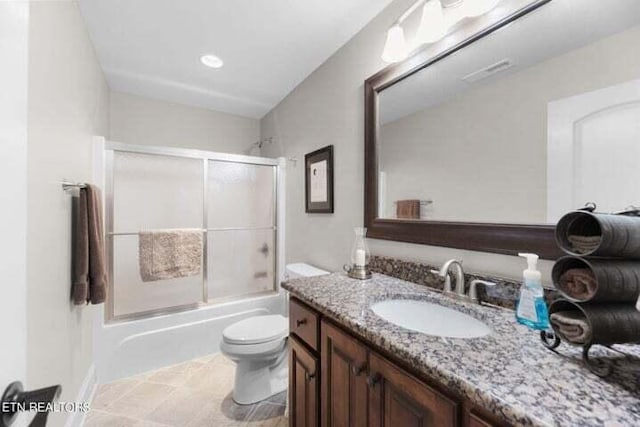 full bathroom with toilet, vanity, and bath / shower combo with glass door