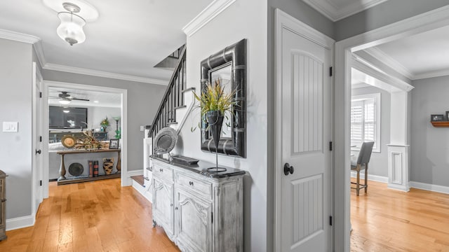 hallway with light hardwood / wood-style floors and crown molding