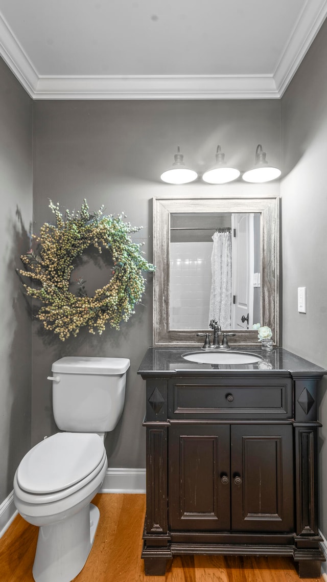 bathroom featuring vanity, hardwood / wood-style flooring, toilet, and ornamental molding