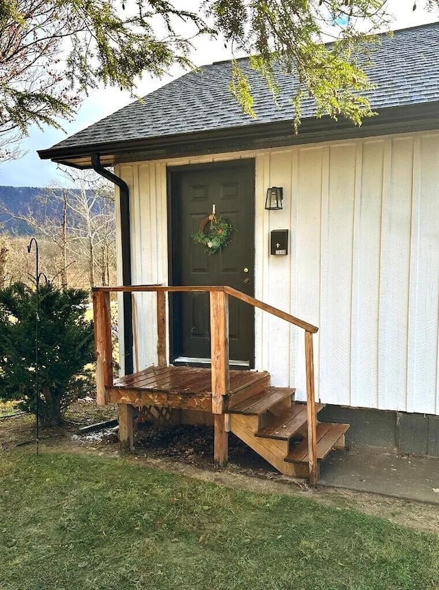 property entrance featuring roof with shingles