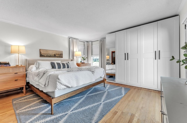 bedroom with light wood-style flooring and a textured ceiling