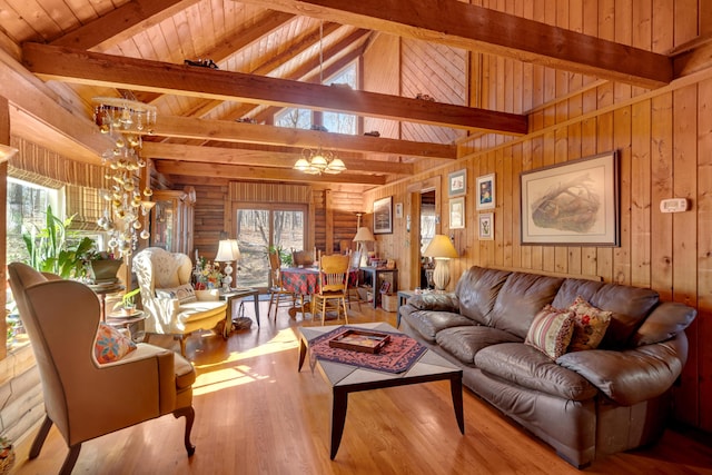 living room featuring light hardwood / wood-style floors, wooden ceiling, lofted ceiling with beams, and an inviting chandelier