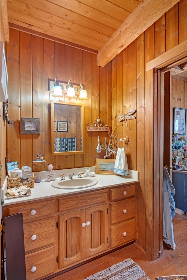 bathroom featuring vanity, wood walls, beam ceiling, hardwood / wood-style flooring, and wood ceiling