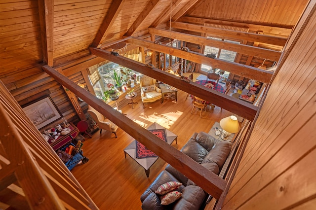 living room featuring wood walls, wooden ceiling, beam ceiling, and plenty of natural light