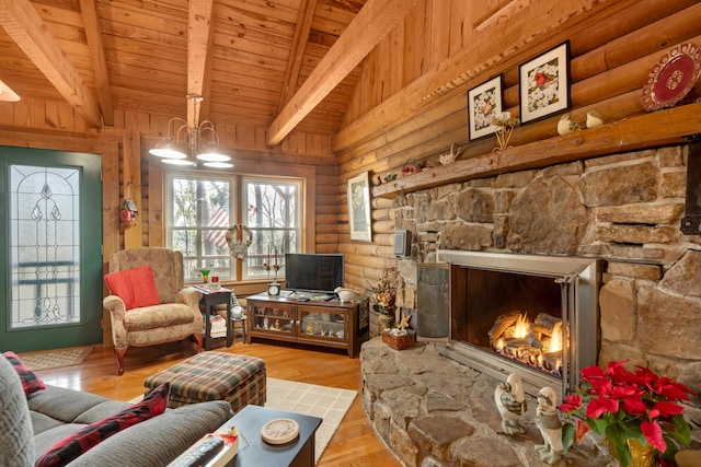 interior space featuring log walls, a stone fireplace, vaulted ceiling with beams, wooden ceiling, and light hardwood / wood-style flooring