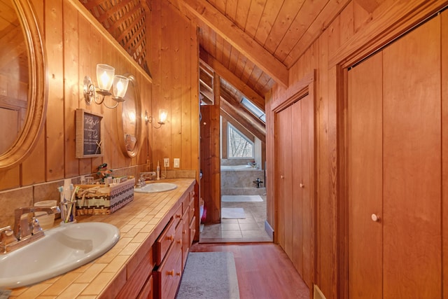 bathroom with hardwood / wood-style floors, vanity, a tub, vaulted ceiling, and wooden ceiling