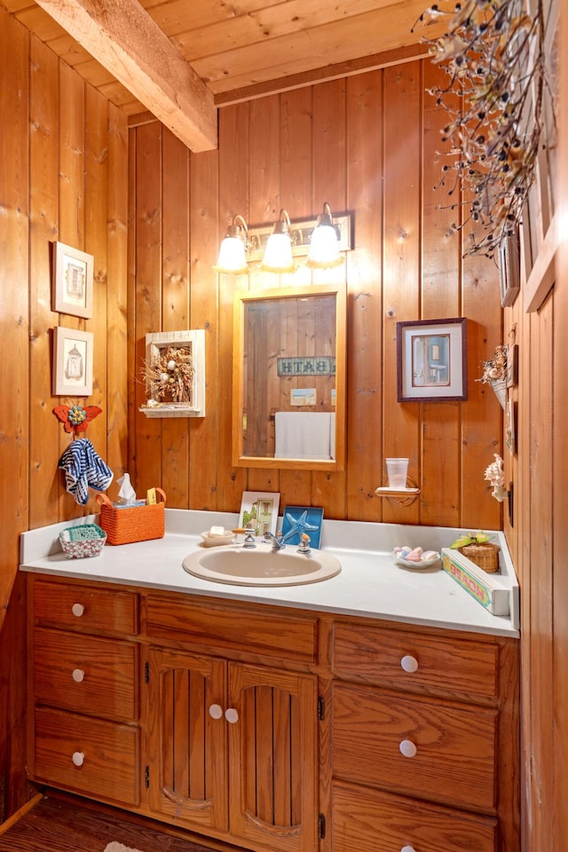 bathroom featuring wood ceiling, vanity, beamed ceiling, wooden walls, and hardwood / wood-style flooring