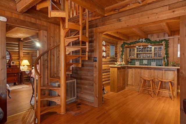 interior space featuring wood ceiling, log walls, hardwood / wood-style floors, and beamed ceiling