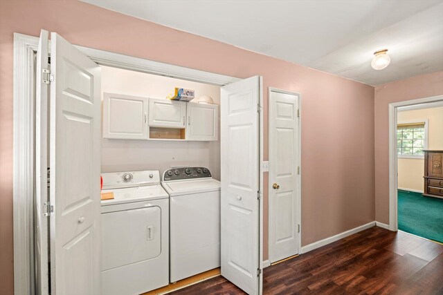 washroom featuring washer and clothes dryer, cabinets, and dark wood-type flooring