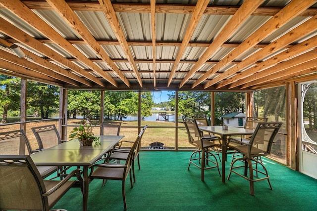 sunroom featuring a water view