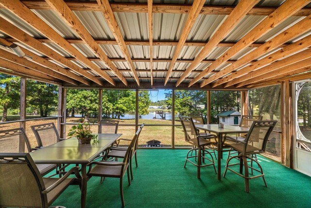 sunroom featuring a water view