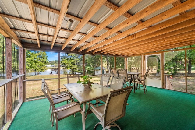 unfurnished sunroom with a water view and vaulted ceiling