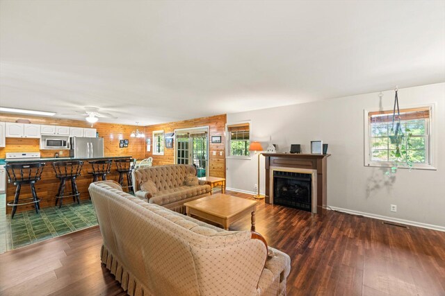 living room featuring a wealth of natural light, dark hardwood / wood-style flooring, and ceiling fan