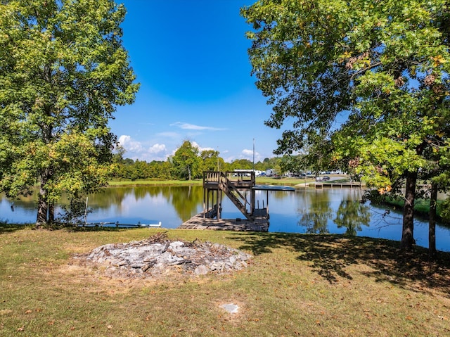 view of dock featuring a lawn and a water view